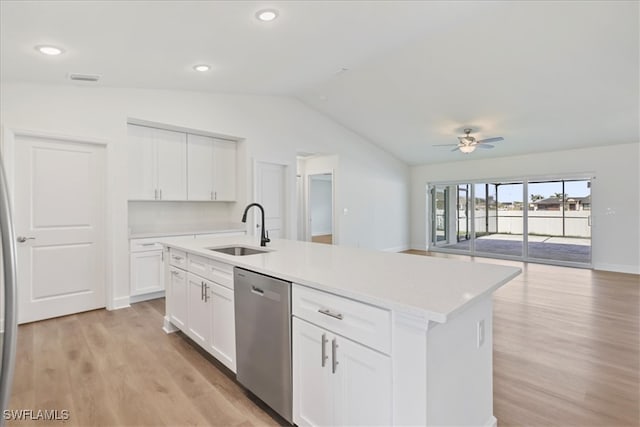 kitchen featuring a sink, open floor plan, stainless steel dishwasher, light wood-style floors, and lofted ceiling