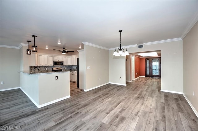1910 Virginia Ave Unit 1302, Fort Myers, FL 33901 - kitchen with stainless steel appliances, open floor plan, backsplash, a peninsula, and light wood-style floors