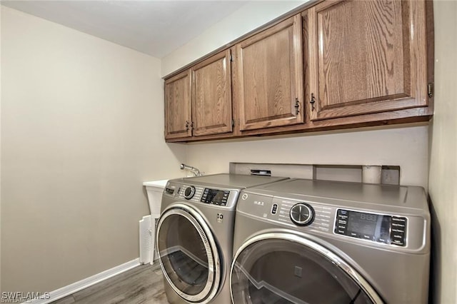 1910 Virginia Ave Unit 1302, Fort Myers, FL 33901 - laundry room featuring cabinet space, washing machine and dryer, baseboards, and wood finished floors
