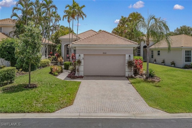view of front of house with an attached garage, driveway, stucco siding, a front lawn, and a tile roof
