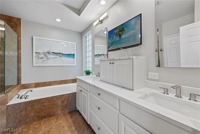 full bathroom featuring a garden tub, double vanity, and recessed lighting
