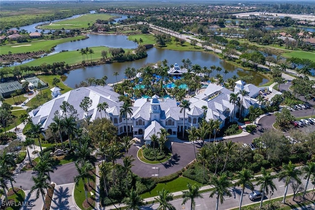 view of property location featuring a large body of water, a golf club, and nearby suburban area