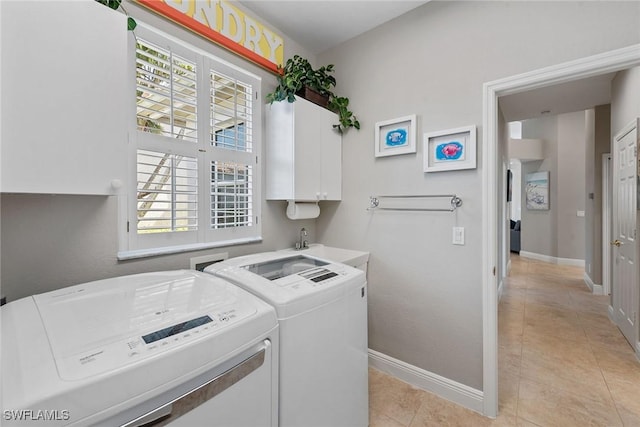 clothes washing area with independent washer and dryer, cabinet space, baseboards, and light tile patterned flooring
