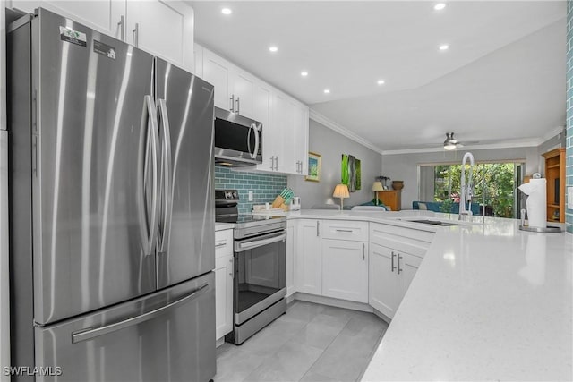 773 Wiggins Lake Dr Unit 102, Naples, FL 34110 - kitchen with stainless steel appliances, a sink, white cabinets, ceiling fan, and ornamental molding