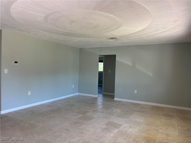 spare room with baseboards and visible vents
