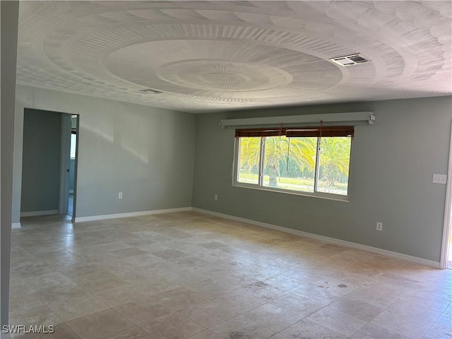 unfurnished room featuring baseboards and visible vents