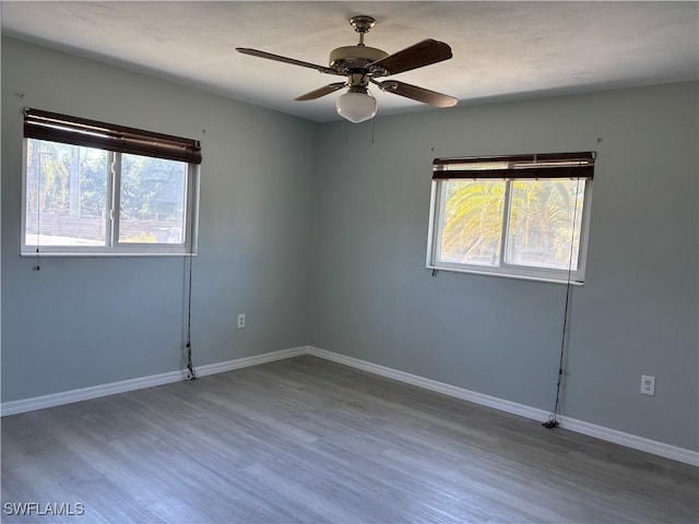 unfurnished room featuring wood finished floors, baseboards, and ceiling fan