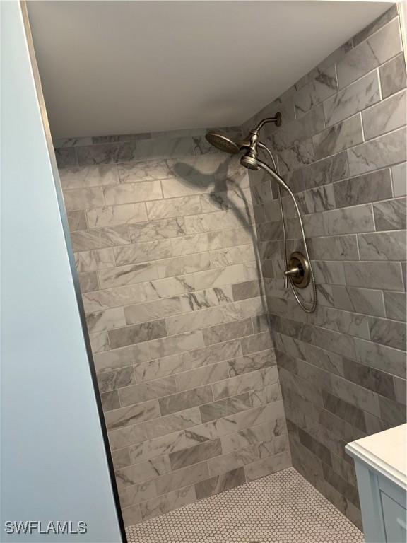 full bath featuring vanity and tiled shower