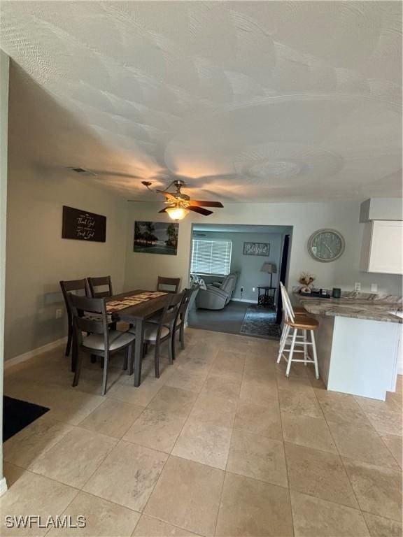 dining area with baseboards, light tile patterned flooring, and ceiling fan