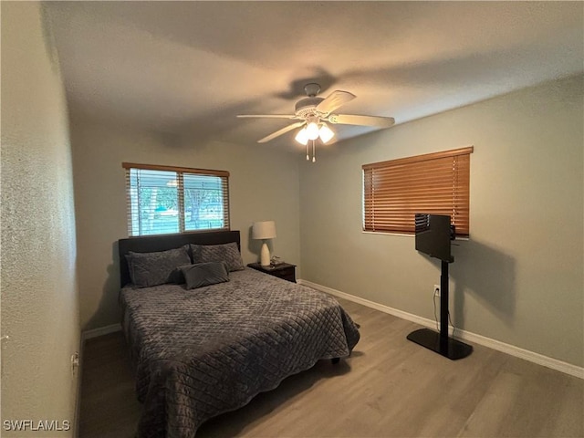 bedroom with baseboards, ceiling fan, and wood finished floors