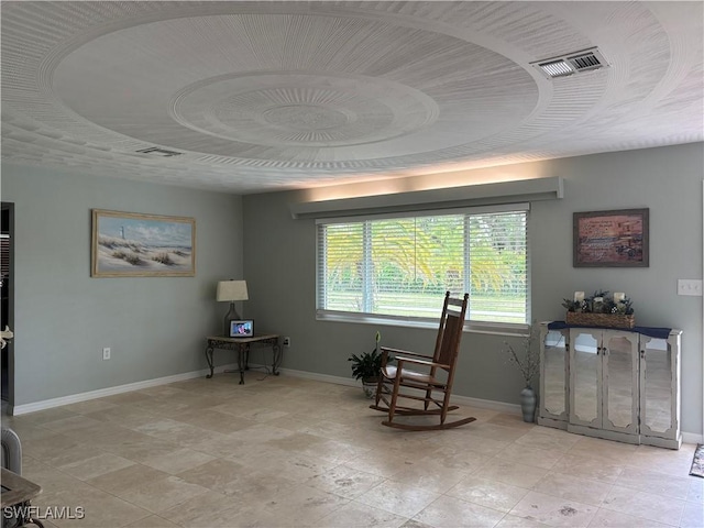 living area with baseboards and visible vents