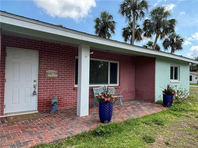 view of exterior entry with brick siding
