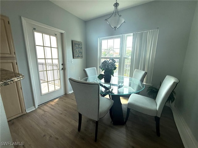 dining space featuring baseboards and wood finished floors