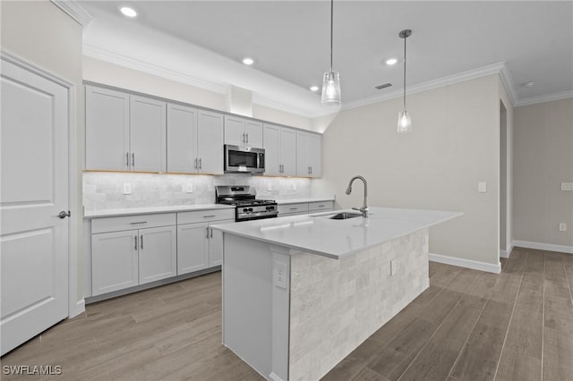 19402 Hinkley Dr, Estero, FL 33928 - kitchen featuring appliances with stainless steel finishes, a sink, light wood-style floors, tasteful backsplash, and crown molding