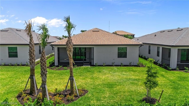 19402 Hinkley Dr, Estero, FL 33928 - back of property with a tile roof, a yard, a sunroom, and stucco siding