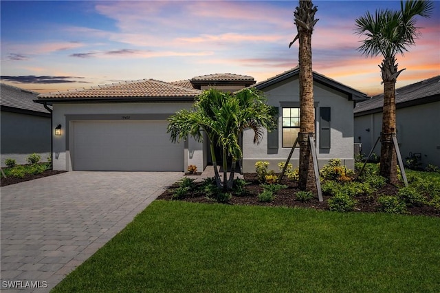 19402 Hinkley Dr, Estero, FL 33928 - view of front facade with stucco siding, a garage, decorative driveway, a front yard, and a tiled roof