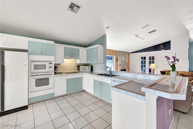 1273 Naples Lake Dr, Naples, FL 34104 - kitchen featuring tile countertops, white appliances, visible vents, a peninsula, and vaulted ceiling