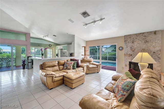1273 Naples Lake Dr, Naples, FL 34104 - living area with rail lighting, lofted ceiling, a wealth of natural light, and light tile patterned floors