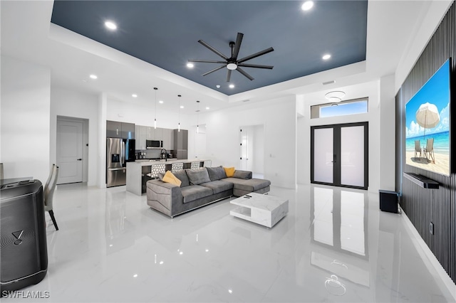 living area with a tray ceiling, a ceiling fan, and recessed lighting