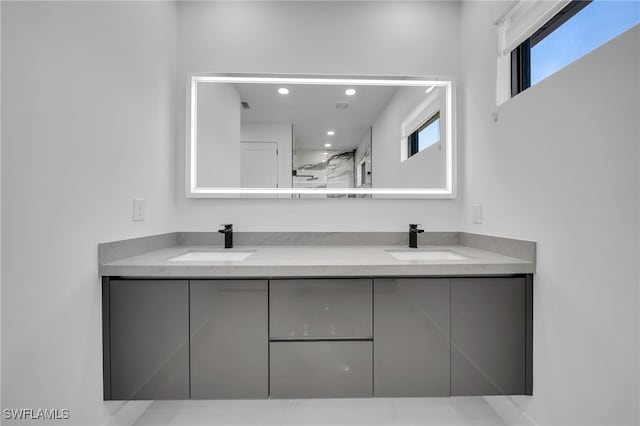 bathroom featuring a wealth of natural light, double vanity, and a sink