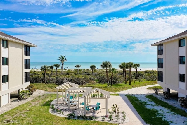 view of yard featuring a pergola, a water view, and a patio