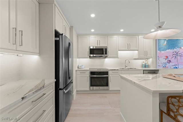 kitchen featuring a sink, recessed lighting, backsplash, white cabinetry, and appliances with stainless steel finishes
