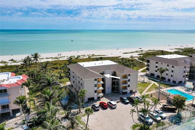 birds eye view of property featuring a water view and a beach view