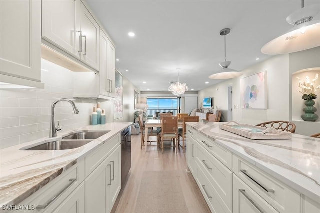 kitchen with a sink, white cabinetry, and backsplash