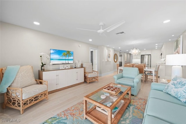 living area featuring recessed lighting, light wood-style floors, visible vents, and ceiling fan with notable chandelier