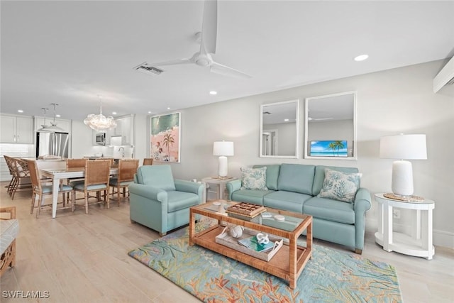 living area with light wood-style flooring, visible vents, and recessed lighting