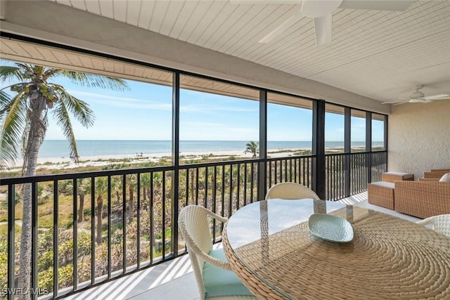 sunroom with a view of the beach and a water view