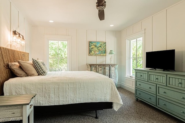 bedroom with a decorative wall, dark colored carpet, ceiling fan, and recessed lighting