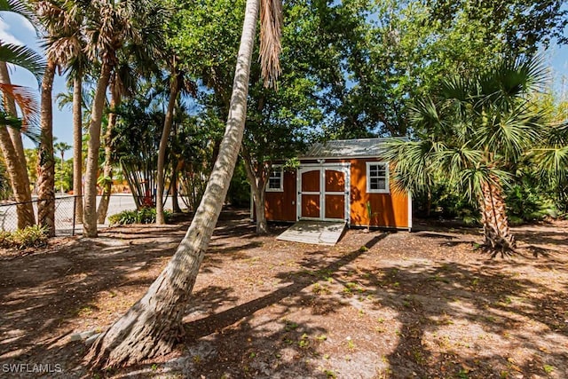 view of shed featuring fence