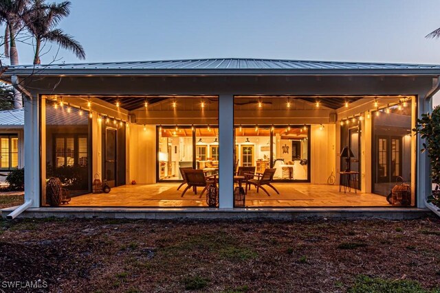 rear view of property with french doors, metal roof, and a deck