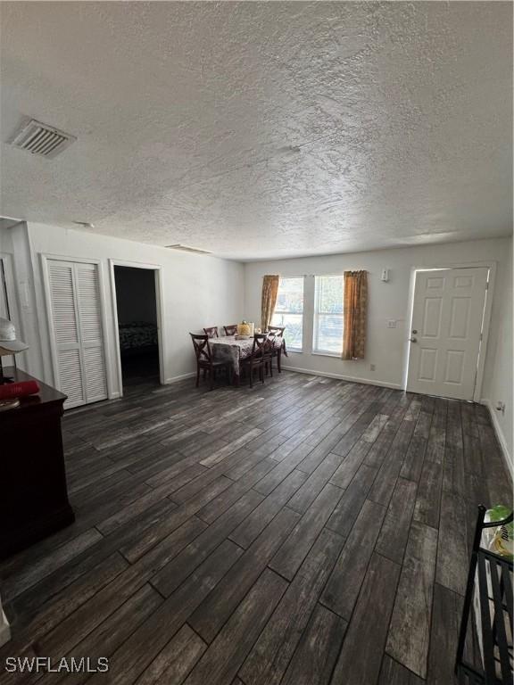 11688 Saunders Ave, Bonita Springs, FL 34135 - dining space featuring a textured ceiling, visible vents, and dark wood finished floors