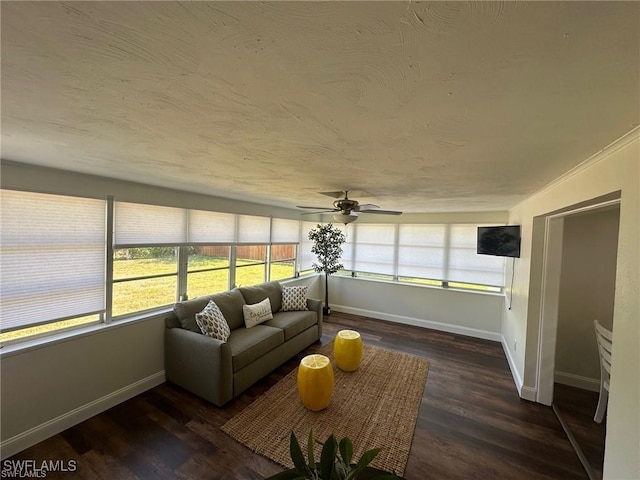 sunroom featuring baseboards, wood finished floors, and a textured ceiling