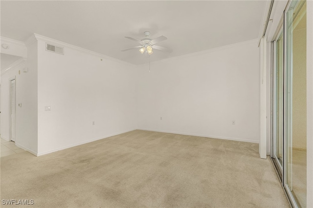 empty room featuring light carpet, crown molding, a ceiling fan, and baseboards