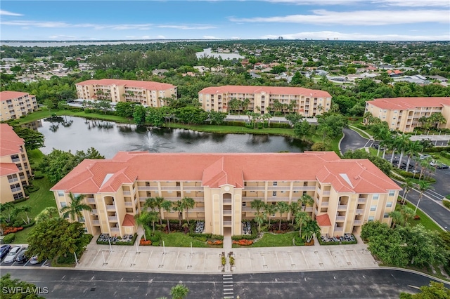 drone / aerial view of apartment complex and a nearby body of water