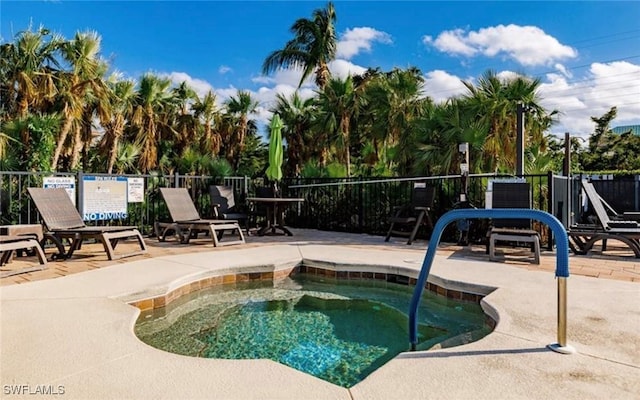view of swimming pool with fence, a hot tub, and a patio