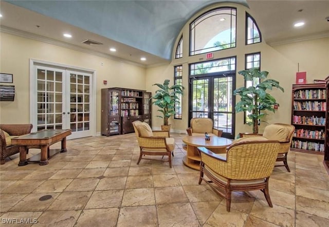 lobby with ornamental molding, recessed lighting, and a towering ceiling