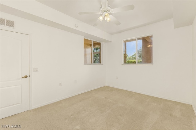empty room featuring light colored carpet, baseboards, and a ceiling fan