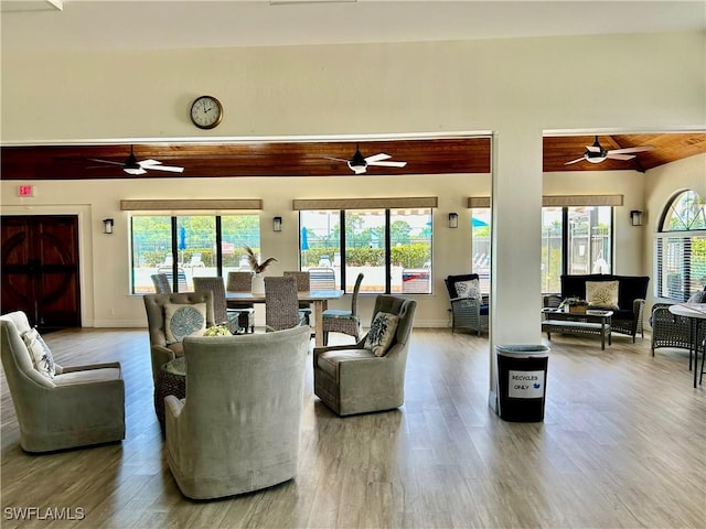 living area featuring plenty of natural light, wood finished floors, a ceiling fan, lofted ceiling, and wooden ceiling
