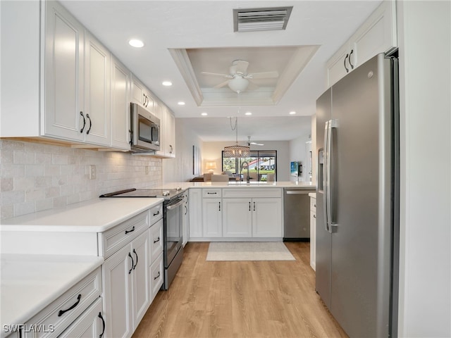 13111 Cross Creek Blvd Unit 208, Fort Myers, FL 33912 - kitchen featuring appliances with stainless steel finishes, a raised ceiling, ceiling fan, light wood-type flooring, and a peninsula