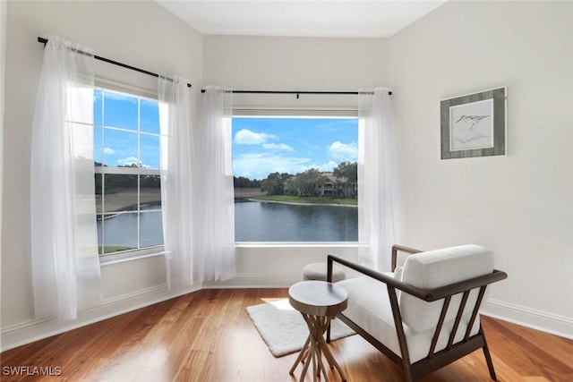 26271 Devonshire Ct Unit 202, Bonita Springs, FL 34134 - sitting room with wood finished floors, baseboards, and a water view