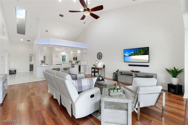 26271 Devonshire Ct Unit 202, Bonita Springs, FL 34134 - living area with high vaulted ceiling, ceiling fan, light wood-style floors, and baseboards