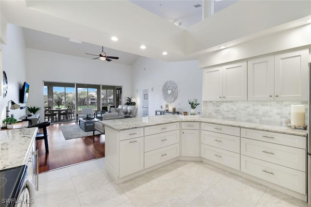 26271 Devonshire Ct Unit 202, Bonita Springs, FL 34134 - kitchen with high vaulted ceiling, a peninsula, ceiling fan, stainless steel range with electric cooktop, and recessed lighting