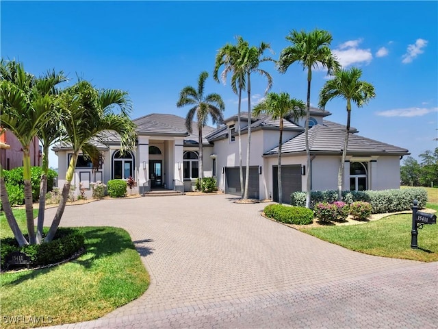 15411 Catalpa Cove Ln, Fort Myers, FL 33908 - view of front of home featuring a front yard, stucco siding, an attached garage, and curved driveway