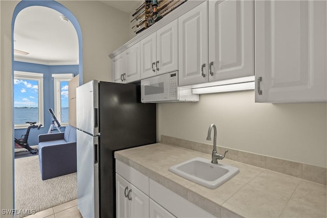 15411 Catalpa Cove Ln, Fort Myers, FL 33908 - kitchen featuring freestanding refrigerator, a sink, white microwave, light countertops, and white cabinets