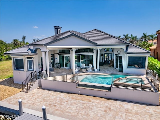 15411 Catalpa Cove Ln, Fort Myers, FL 33908 - back of house featuring a patio area, a jacuzzi, an outdoor pool, and a tile roof