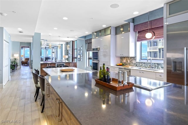 14220 Royal Harbour Ct Unit 607, Fort Myers, FL 33908 - kitchen featuring stainless steel appliances, tasteful backsplash, a peninsula, pendant lighting, and glass insert cabinets